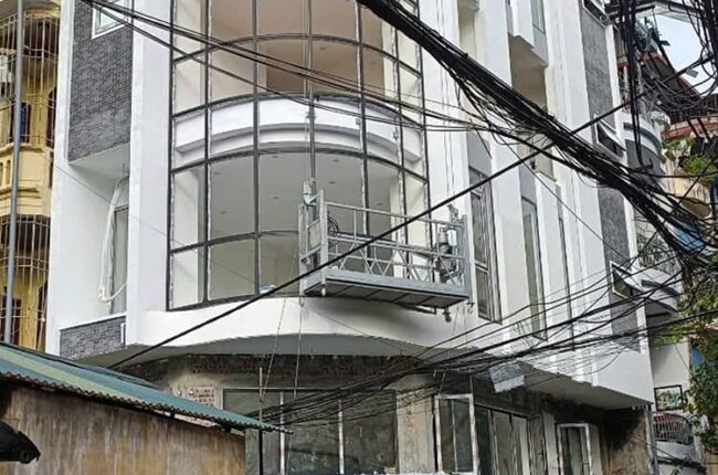 Giàn treo gondola đang làm việc trên mặt tiền tòa nhà cao tầng.