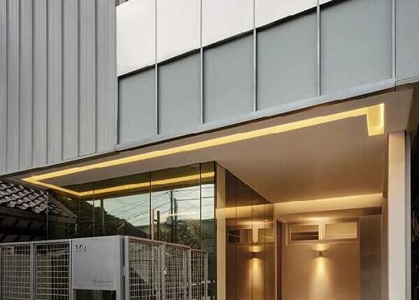 Mặt tiền hiện đại với ánh sáng vàng ấm áp, kiến trúc tối giản.