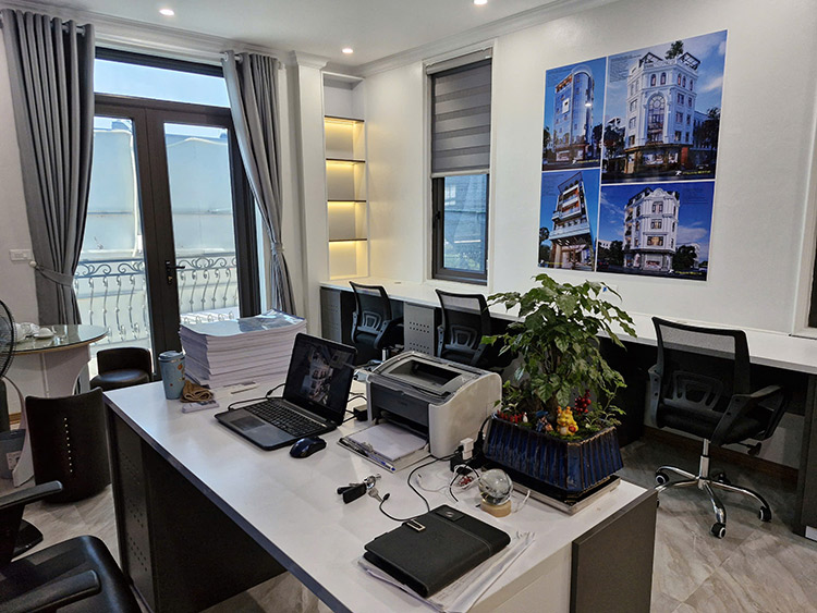 Văn phòng làm việc hiện đại, sáng sủa với cửa sổ lớn và cây xanh.