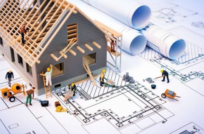 Mô hình nhà đang xây dựng trên bản vẽ kiến trúc chi tiết.